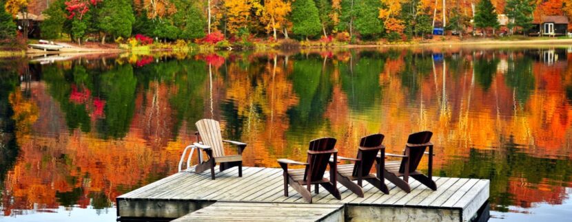 Chairs lakeside amongst vibrant fall foliage