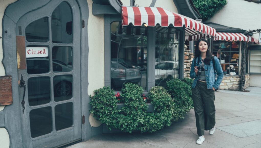 Woman walking through European-esque streets of Carmel, CA