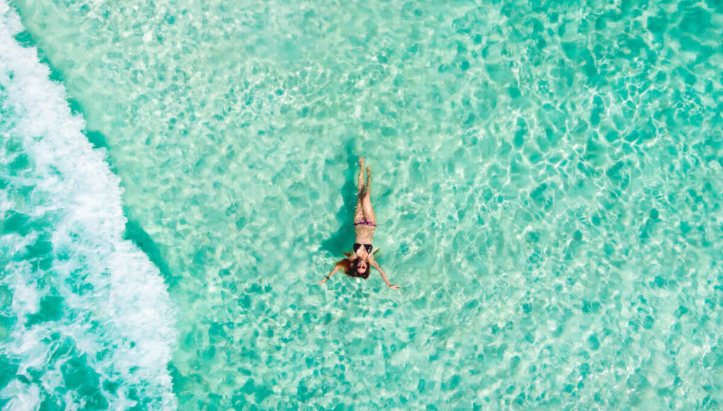 Young Woman Floating In The Caribbean Sea In Mexico