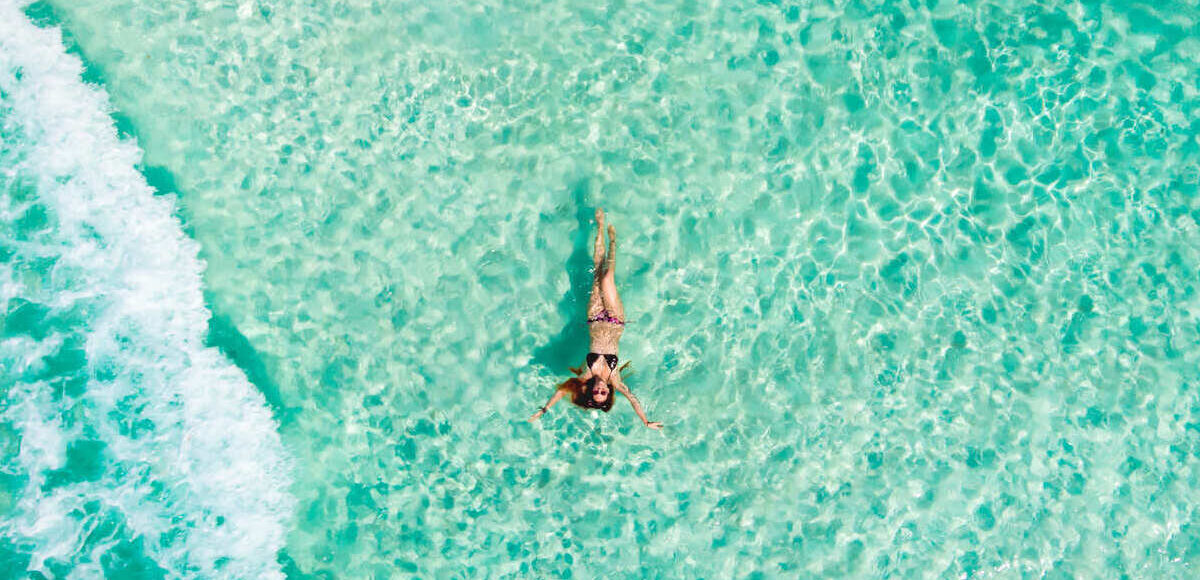 Young Woman Floating In The Caribbean Sea In Mexico