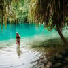 Female tourist in blue water lagoon of Portland, Jamaica