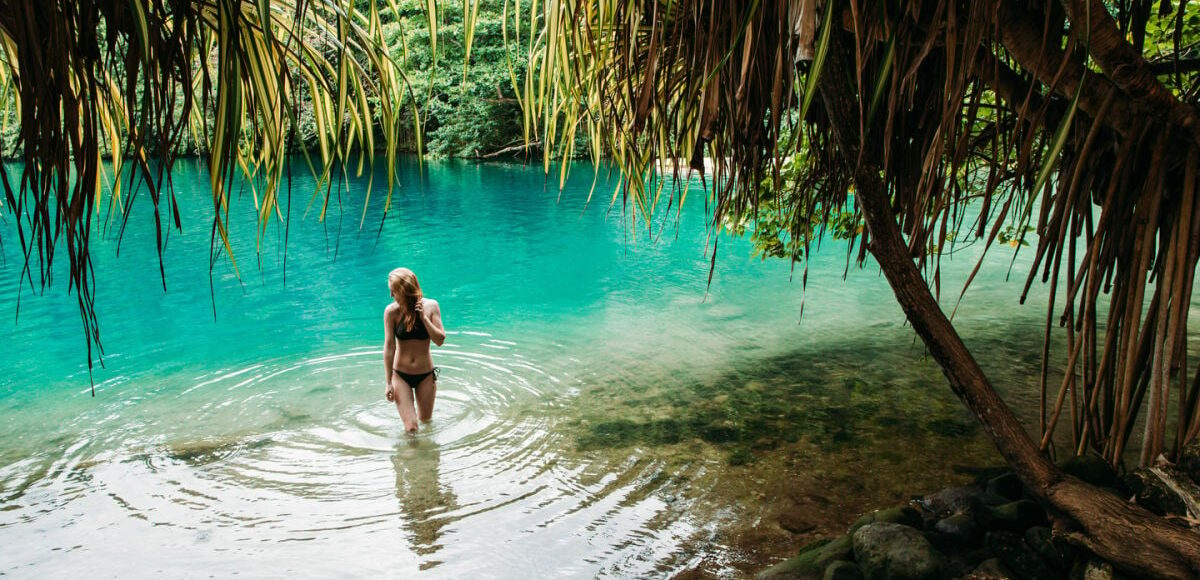 Female tourist in blue water lagoon of Portland, Jamaica