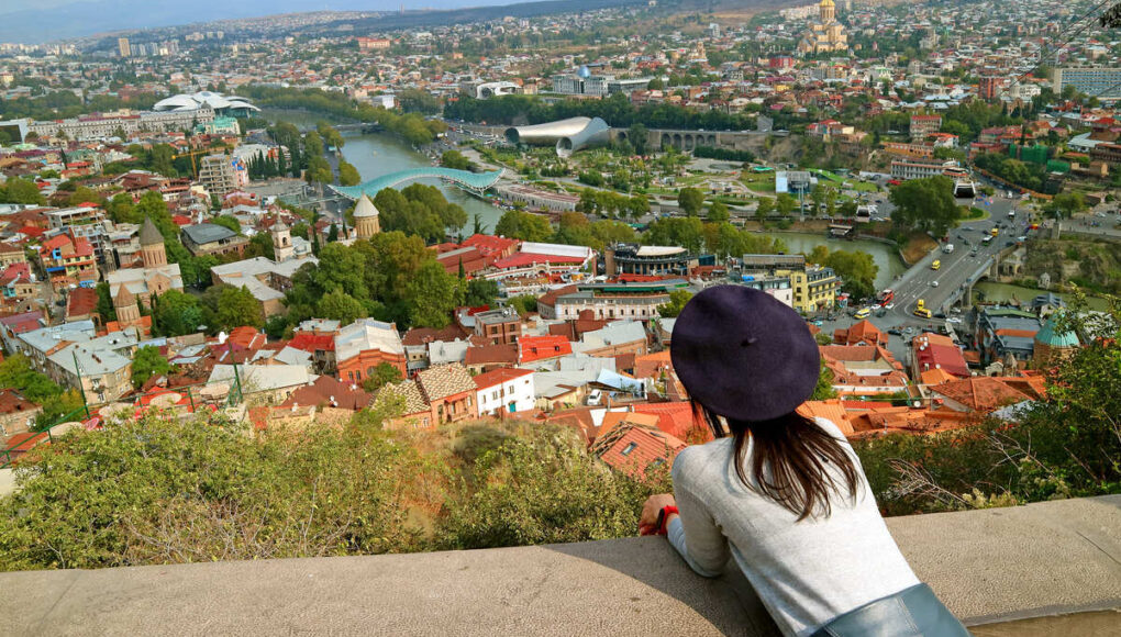 Young Female Tourist Admiring A View Of Narikala Fortress In Tbilisi, Georgia