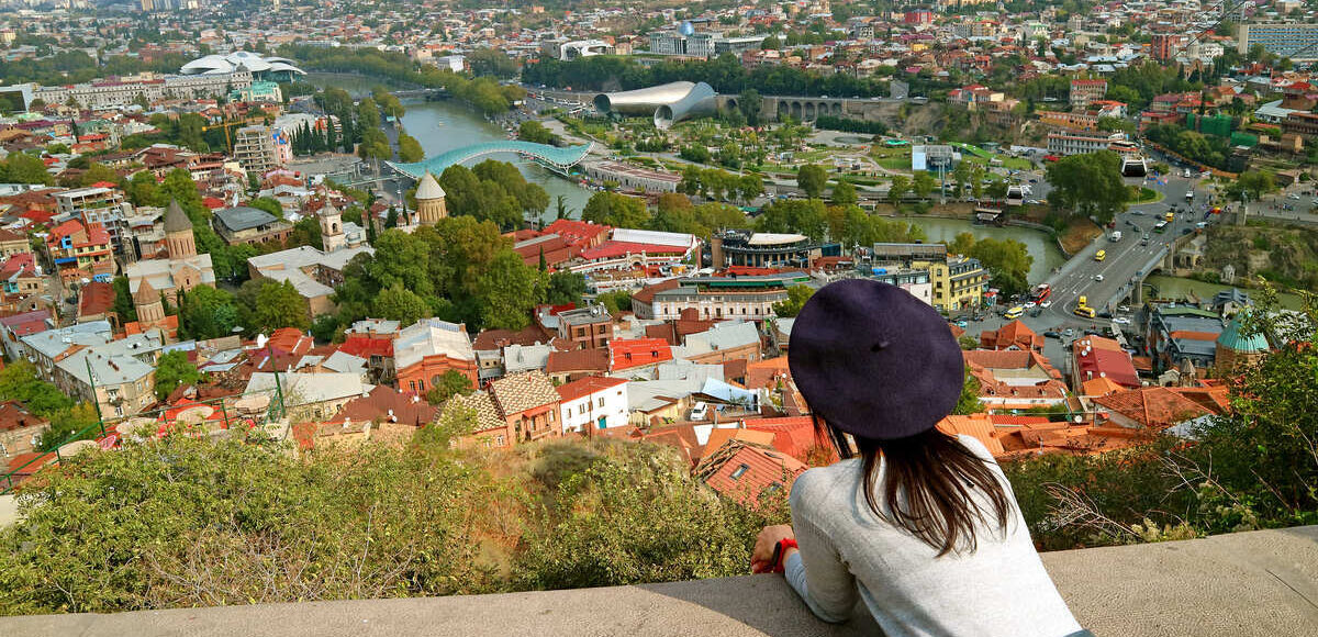 Young Female Tourist Admiring A View Of Narikala Fortress In Tbilisi, Georgia